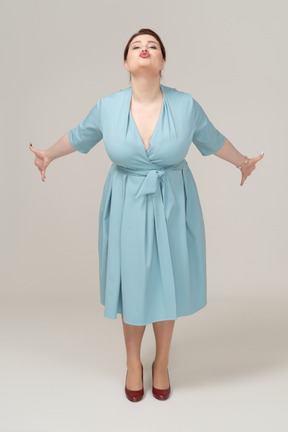 Vue de face d'une femme en robe bleue faisant des grimaces