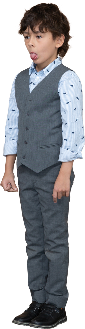 Vista frontal de um lindo garoto de terno cinza mostrando a língua