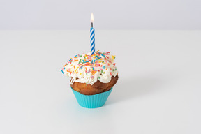 Cupcake with a candle on a white background