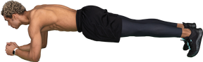 Seitenansicht eines hemdlosen afro-mannes, der in planke auf seinen ellbogen steht
