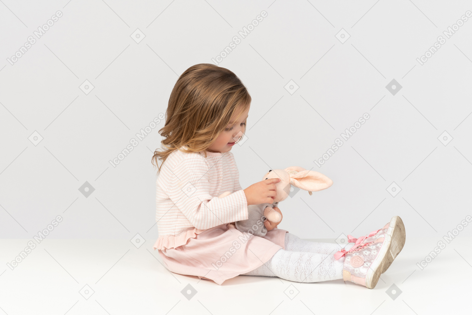 Cute little girl playing with a bunny toy