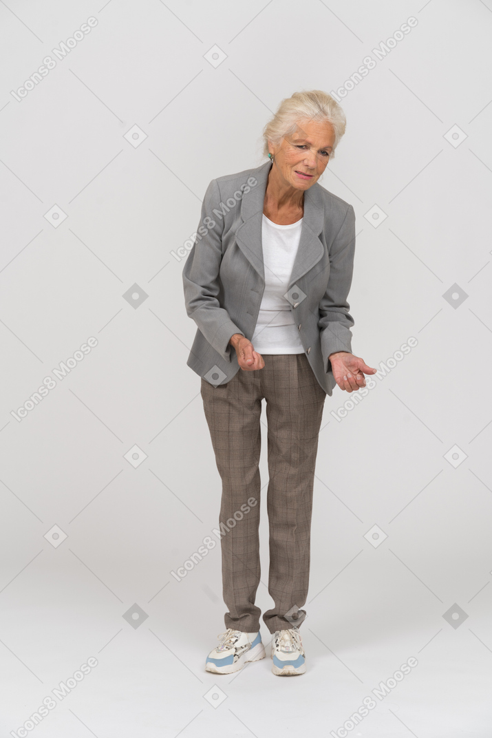 Vue de face d'une vieille dame en costume expliquant quelque chose