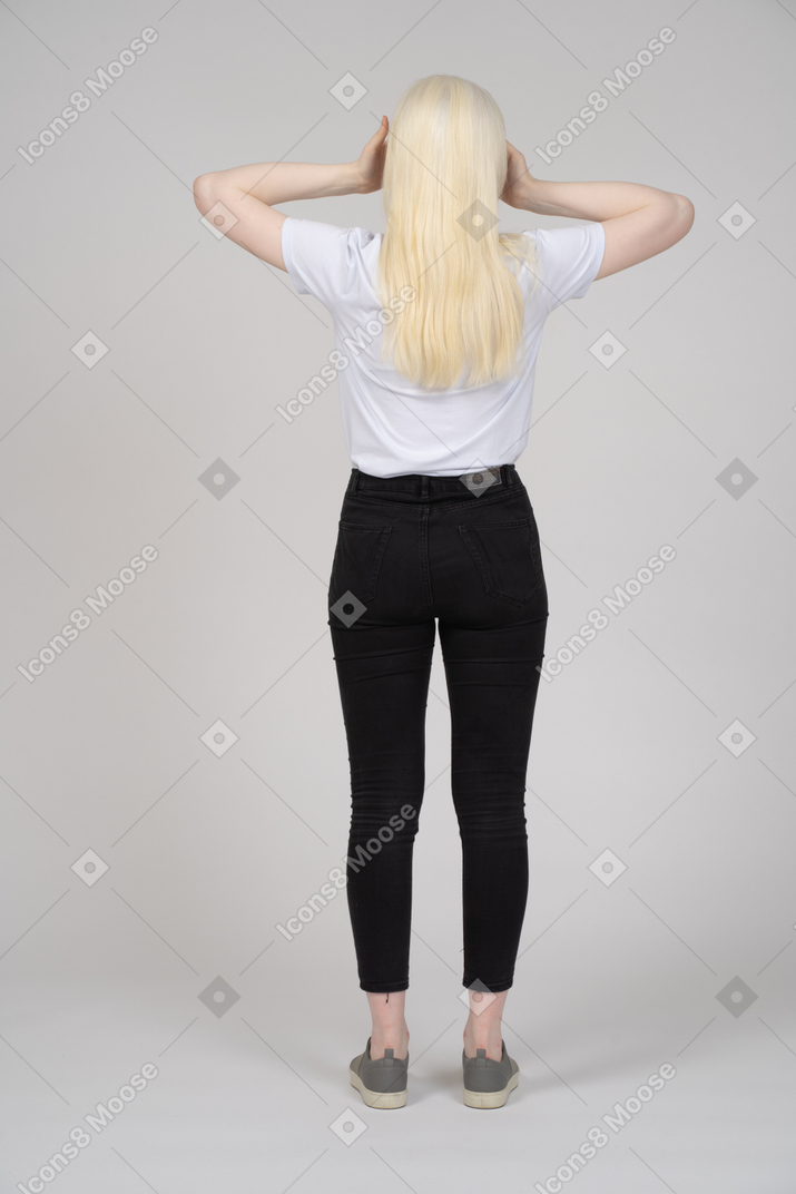 Vista trasera de una mujer de pelo largo sosteniendo su cabeza