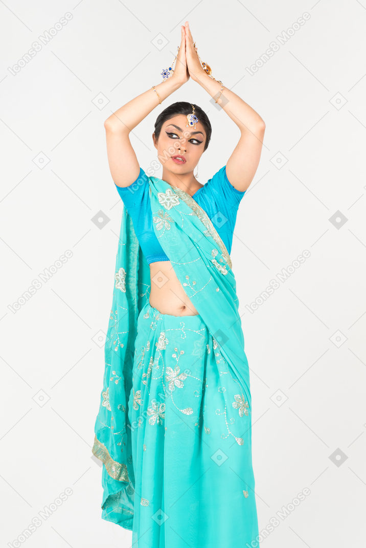 站立在舞蹈位置的蓝色莎丽服的年轻印地安妇女