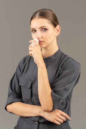 Vista di tre quarti di una giovane donna che piange in una tuta con in mano una salvietta per rimuovere il trucco