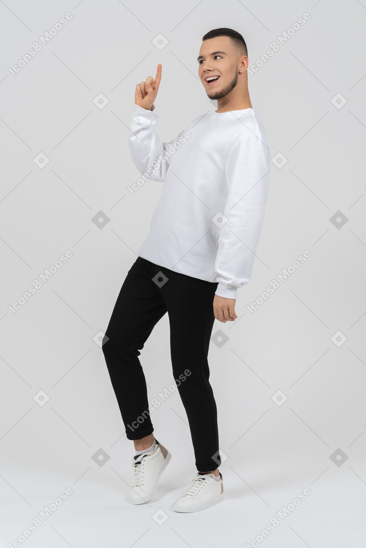 Smiling young man pointing up