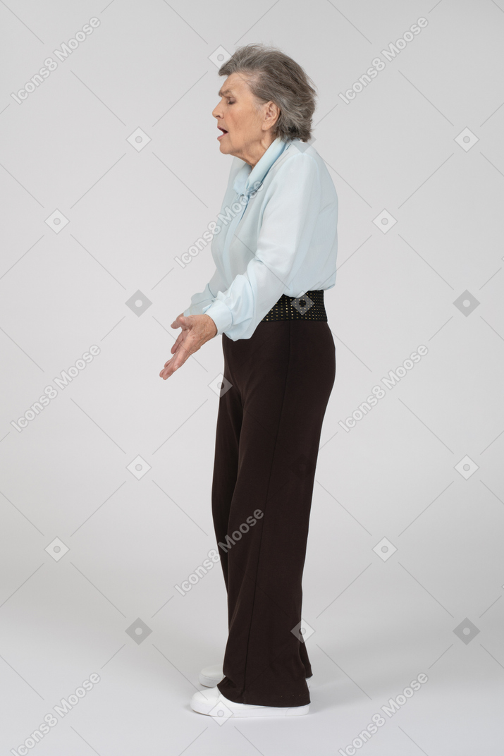 Side view of an old woman shrugging expressively