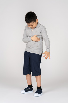 Niño con dolor sosteniendo el estómago