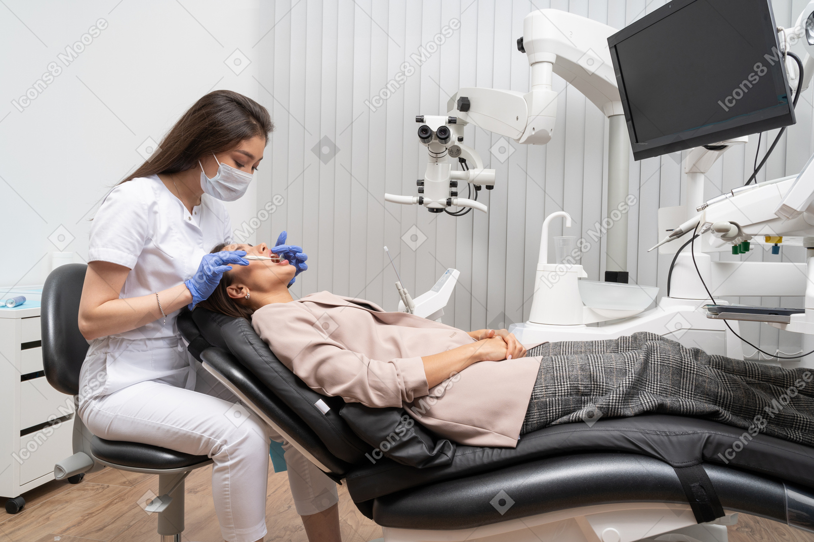 A figura intera di un dentista femminile che esamina il suo paziente