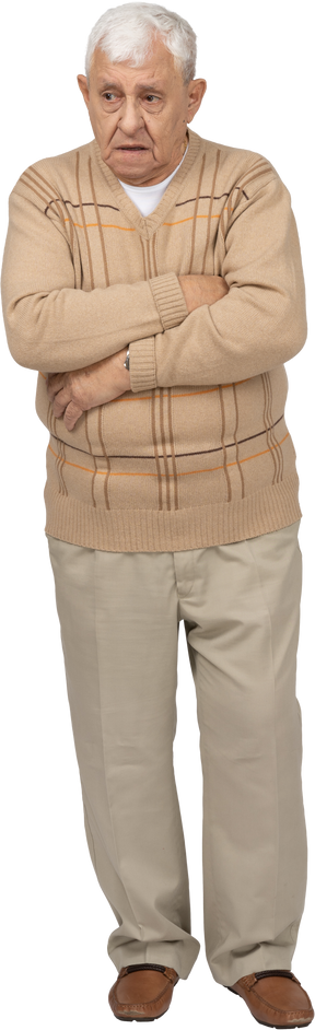 Vue de face d'un vieil homme grincheux dans des vêtements décontractés debout avec les bras croisés