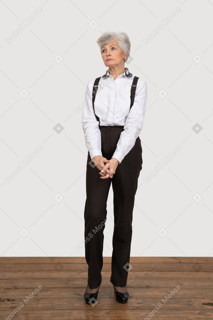 Vista frontal de uma senhora com roupa de escritório, de mãos dadas