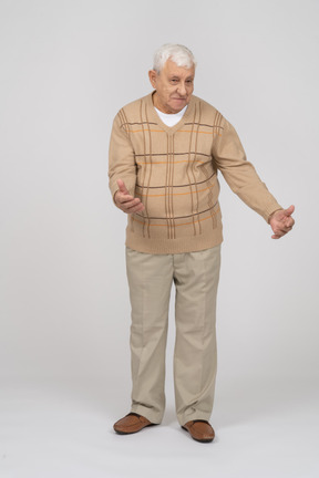 Vue de face d'un vieil homme heureux dans des vêtements décontractés debout avec les bras tendus