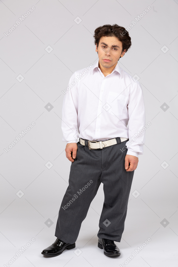 カメラ目線のビジネス カジュアルな服装の若い男