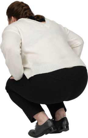 Vista posteriore di una donna plus size in abiti casual accovacciata