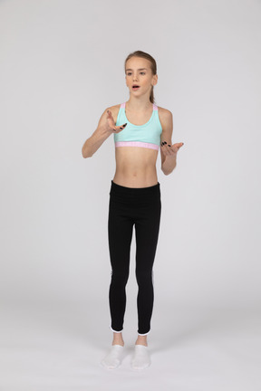 Side view of a teen girl in sportswear raising hand and arguing