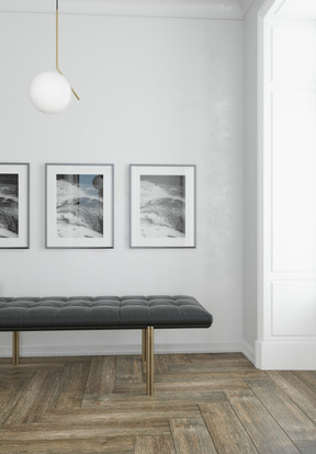 Gray ottoman bench and three posters on the wall