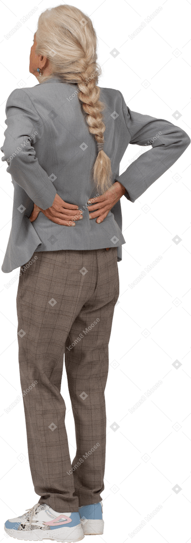 Rear view of an old lady in suit suffering from pain in lower back