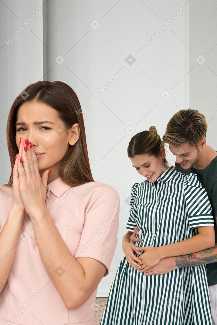Expectant parents and a woman in a pink dress