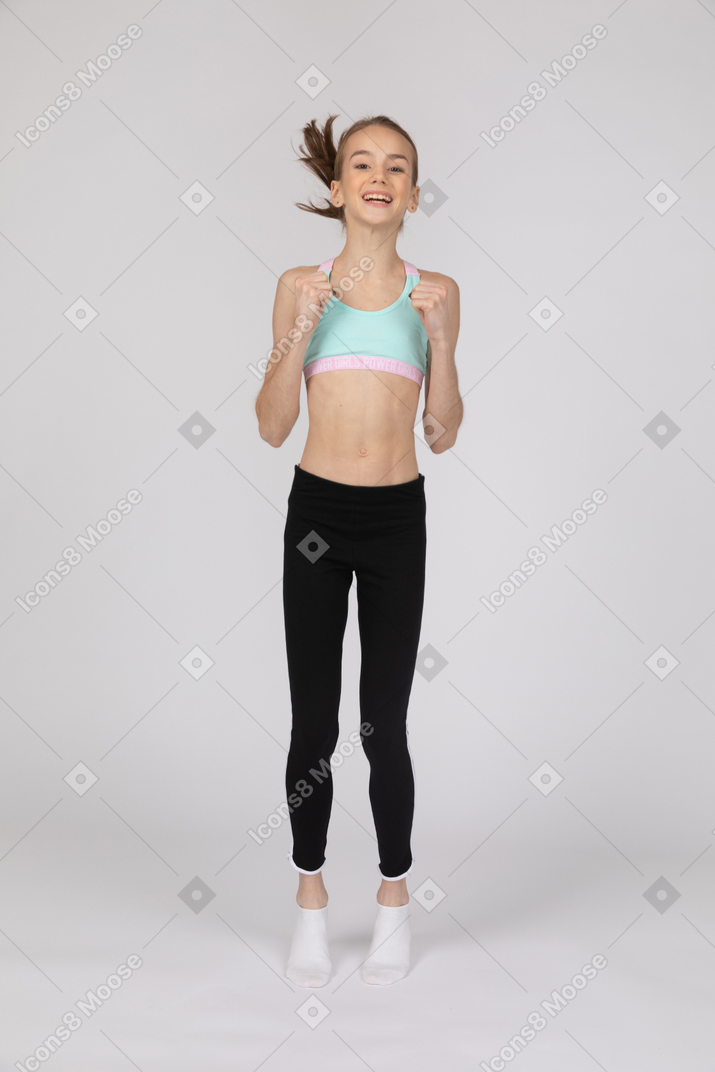 Excited teen girl in sportswear jumping