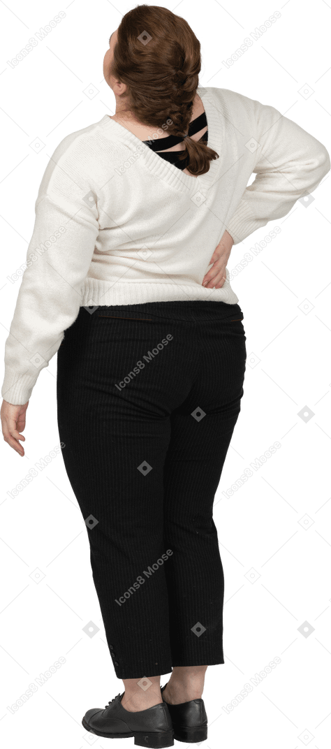 Femme de taille plus en pull blanc souffrant de douleurs dans le bas du dos