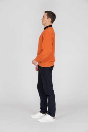 Young man in orange sweatshirt standing