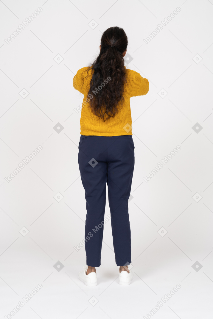 Rear view of a girl in casual clothes covering ears with hands