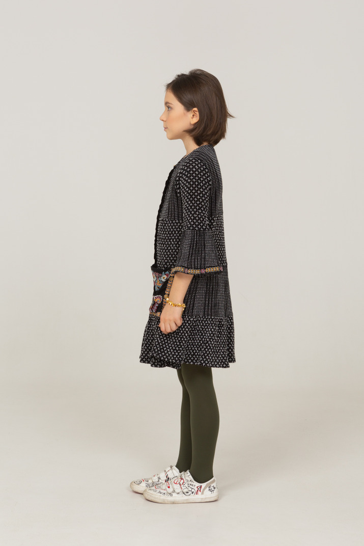 Side View Of A Little Girl In Dress Looking Aside Photo