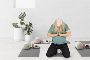 A man praying with his head bowed in a yoga class