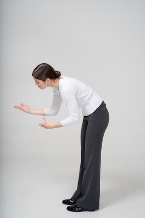 Side view of a woman bending down and explaining something to someone