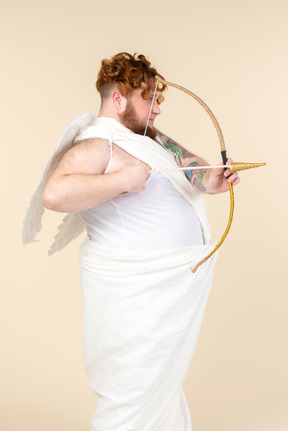 Young big man dressed as a cupid holding bow and arrow