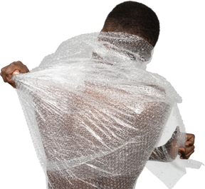 Packansicht eines afrikanischen mannes, der die plastikfolie zerreißt