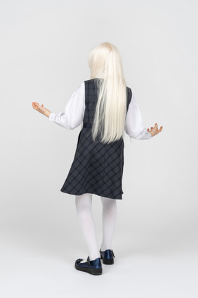 Back view of a schoolgirl raising her arms