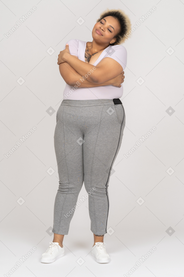 Cute relaxed black woman embracing herself