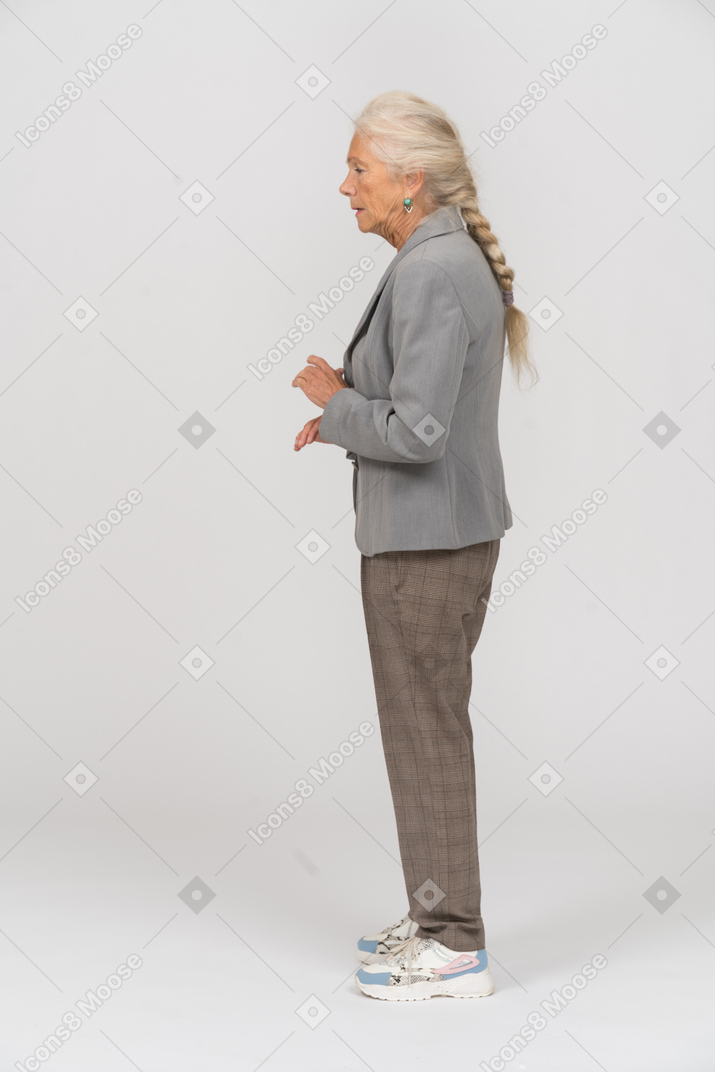 Vecchia signora in abito in piedi di profilo