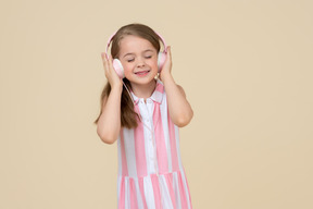 Cute little girl in the headphones listening to a music