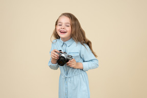 Cute little girl holding a camera