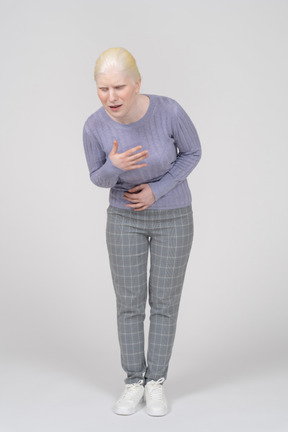 Mujer joven gimiendo con dolor de estómago