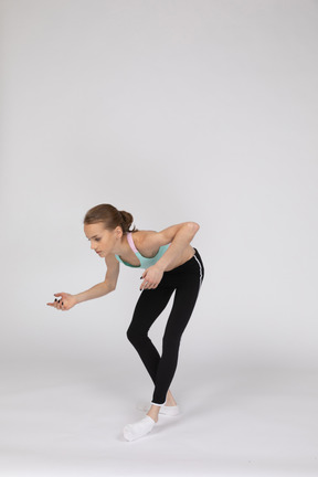 Three-quarter view of a teen girl in sportswear leaning forward