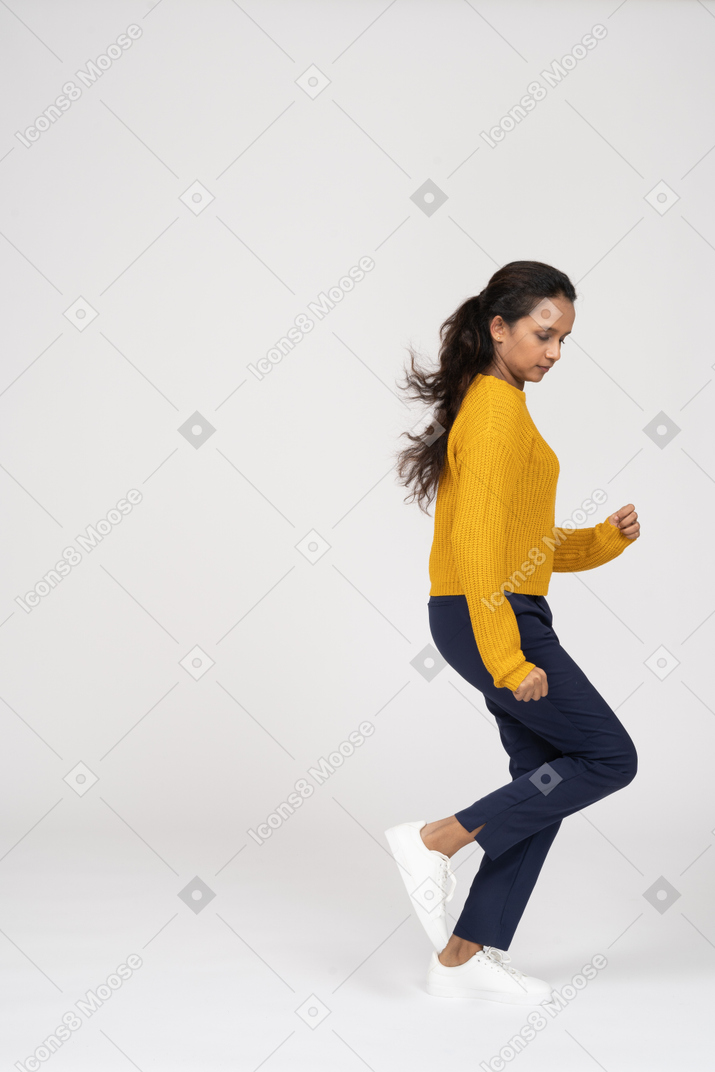 Vista lateral de uma garota com roupas casuais correndo
