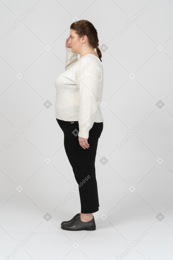 Vista lateral de uma mulher gorducha saudando com a mão