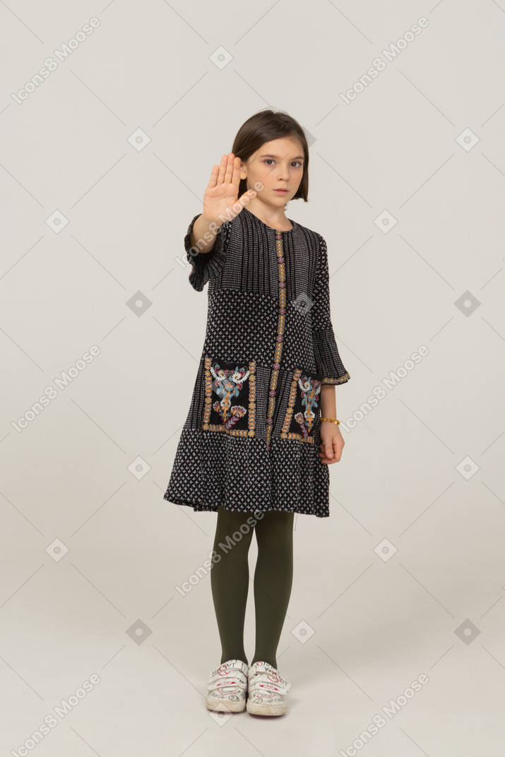 Vista frontale di una bambina in abito che tende la mano