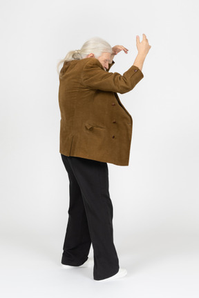 Gray-haired man raising both arms above head