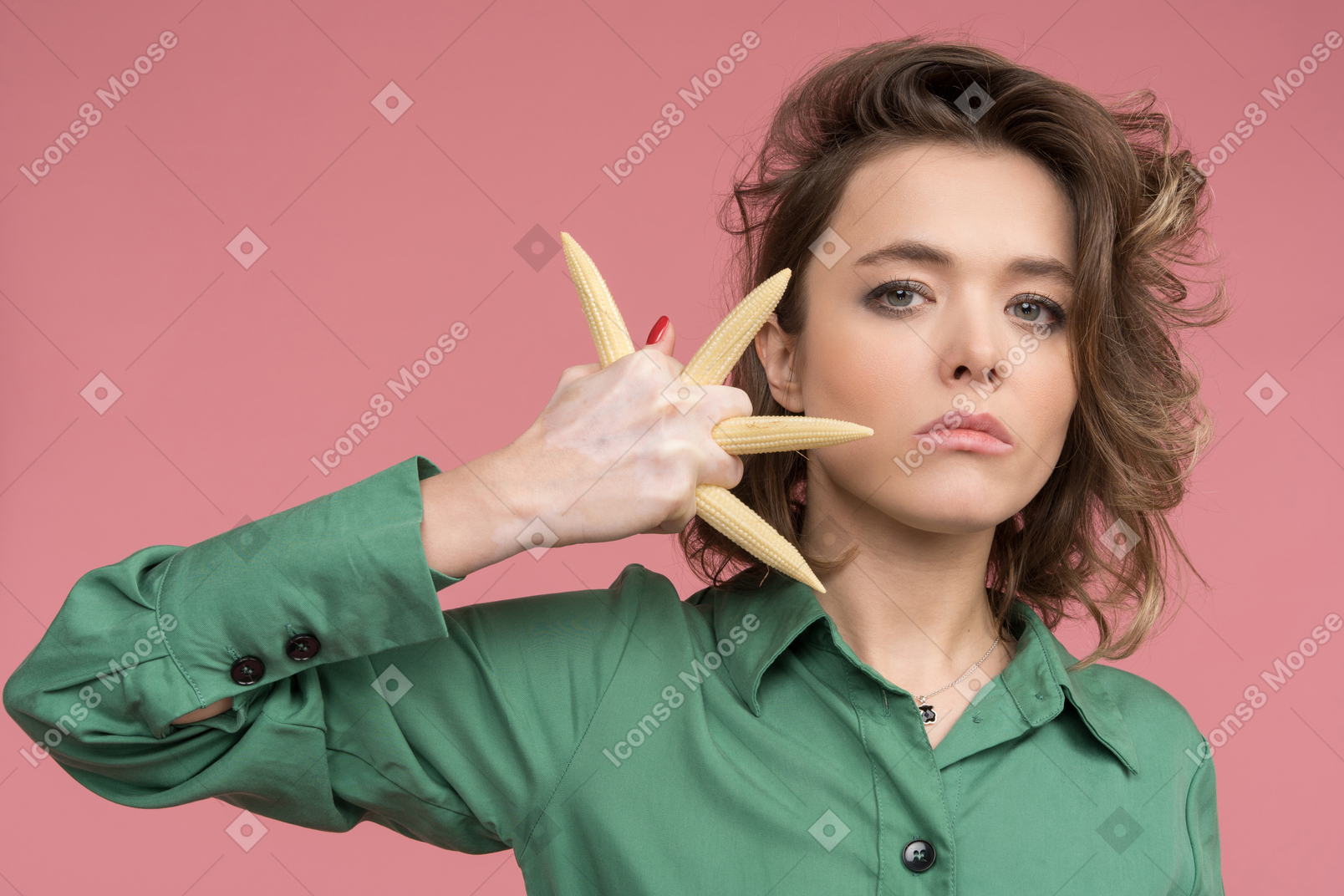 Aggressive woman making a fist with baby corns