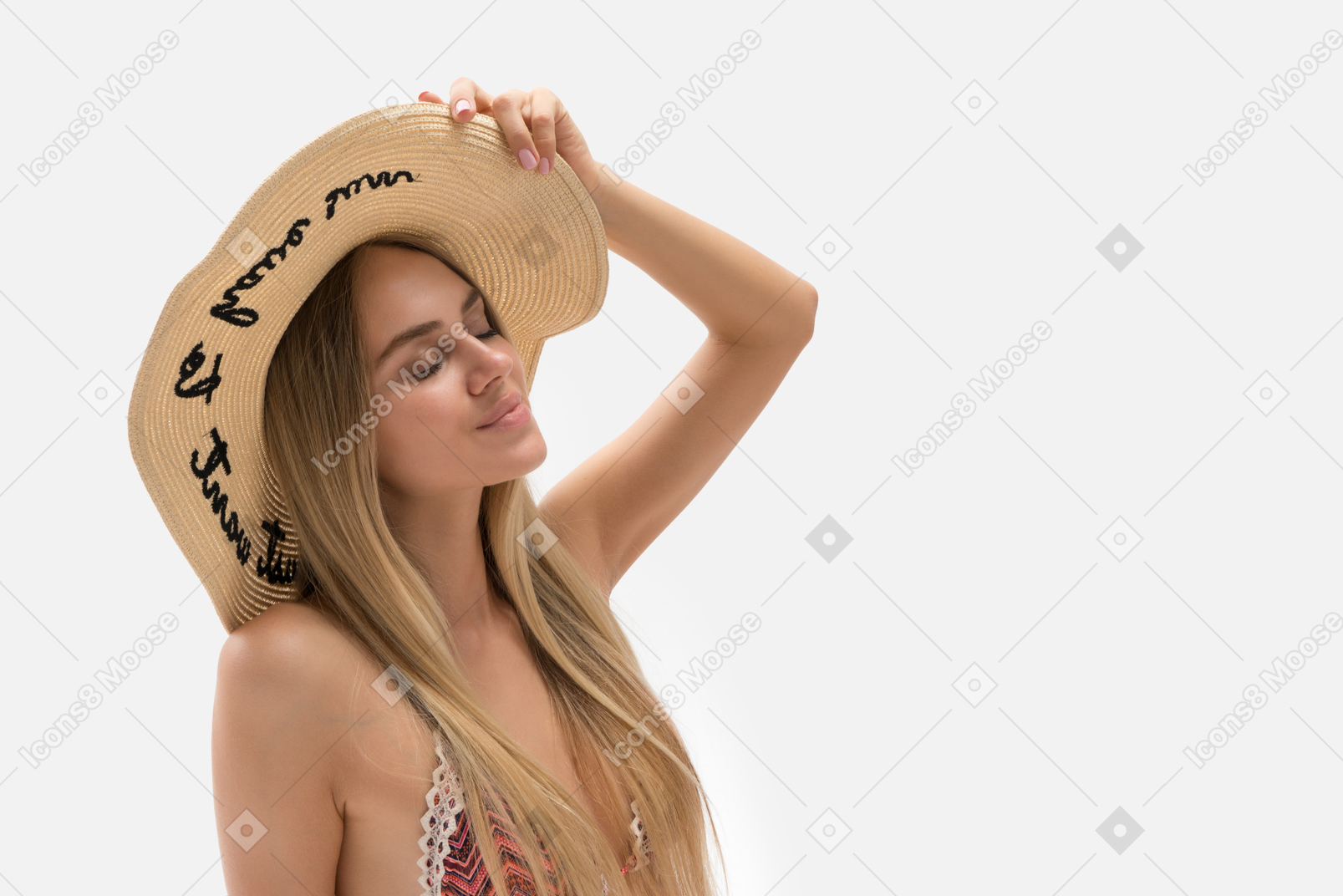 Hermosa joven en bikini y sombrero de paja de pie con los ojos cerrados