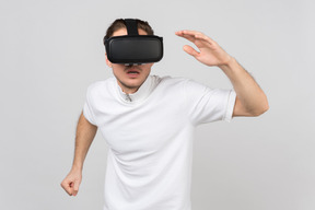 Мужчина в гарнитуре виртуальной реальности бежит куда-то в виртуальной реальности