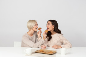 Mujeres jóvenes alimentándose con galletas