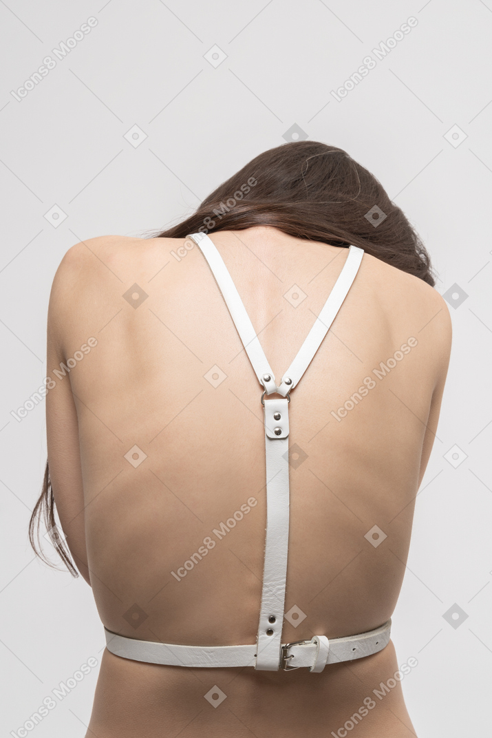 Back view of sexy young woman in harness