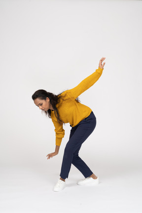 Side view of a girl in casual clothes posing with outstretched arms