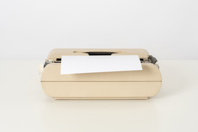 Beige typewriter on a white background
