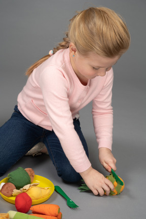 Uma menina brincando com brinquedos de comida